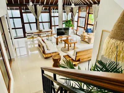 a living room with a couch and a tv at Casa Praja in Seminyak