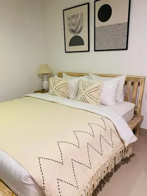 a bedroom with a large bed with black and white pillows at Casa Praja in Seminyak