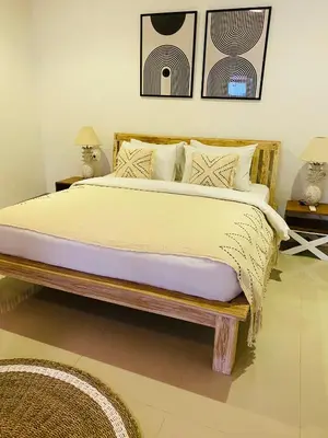 a bedroom with a large bed and two lamps at Casa Praja in Seminyak