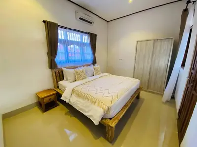 a bedroom with a large bed with a window at Casa Praja in Seminyak
