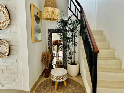 a stairway with a stool and a mirror at Casa Praja in Seminyak