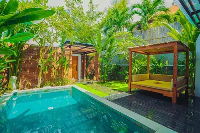 a swimming pool with a bench next to a house at Villa Bulan Bali in Jimbaran