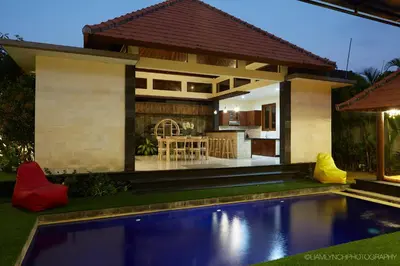 a villa with a swimming pool in front of a house at Villa Nicola in Seminyak