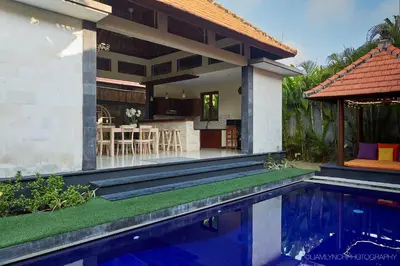 a house with a swimming pool in front of a house at Villa Nicola in Seminyak