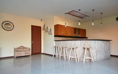a kitchen with a bar with stools in it at Villa Jae in Seminyak