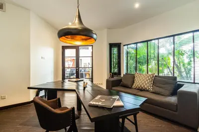 a living room with a table and a couch at PROMO Tropical 3 BD Villa with office and parking in Kerobokan