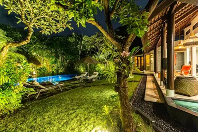 a backyard with a swimming pool and a tree at PROMO Tropical 3 BD Villa with office and parking in Kerobokan