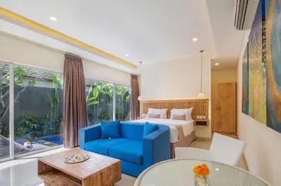 a hotel room with a bed and a blue couch at Le Cielo Romantic Villas by Maviba in Seminyak