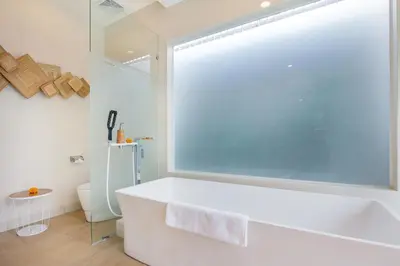 a white bath tub in a bathroom with a window at Le Cielo Romantic Villas by Maviba in Seminyak