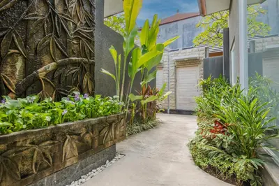 a garden with flowers and plants on a building at Le Cielo Romantic Villas by Maviba in Seminyak