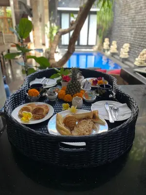 a table with a tray of food on a table at Rahayu Guest House Seminyak in Seminyak