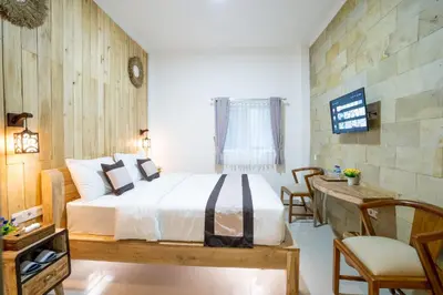 a bedroom with a bed and a table and chairs at Oki Taru Residence in Kuta
