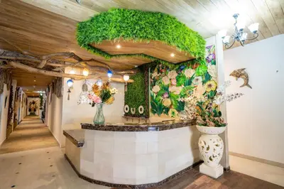 a lobby with a counter with plants on the wall at Oki Taru Residence in Kuta
