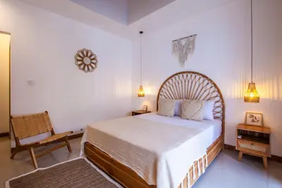 a bedroom with a large bed and a chair at Simple & Magical Villas . Villa Sambali 2 in Kuta
