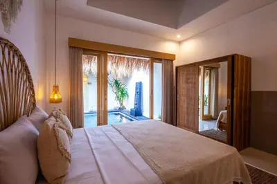 a bedroom with a large bed and a large window at Simple & Magical Villas . Villa Sambali 2 in Kuta