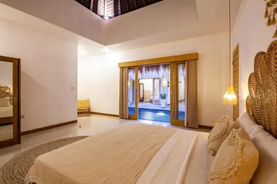 a bedroom with a large bed and a mirror at Simple & Magical Villas . Villa Sambali 2 in Kuta