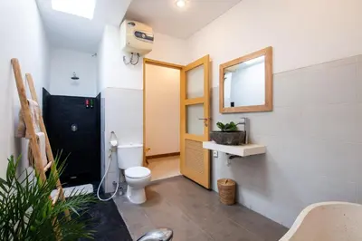 a bathroom with a toilet and a yellow door at Simple & Magical Villas . Villa Sambali 2 in Kuta