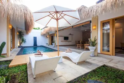 a villa with a swimming pool and an umbrella at Simple & Magical Villas . Villa Sambali 2 in Kuta