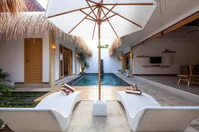 a pool with two chairs and an umbrella at Simple & Magical Villas . Villa Sambali 2 in Kuta