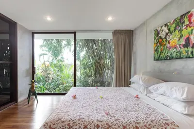 a bedroom with a large bed with a large window at Wahyu wonderful 4Bd villa with huge garden and 2 pools in Seminyak