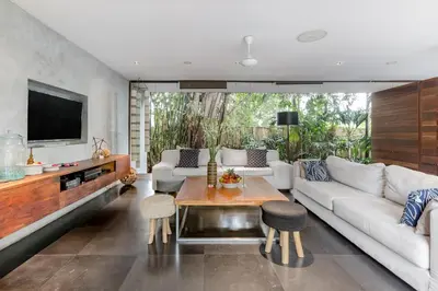 a living room with a white couch and a table at Wahyu wonderful 4Bd villa with huge garden and 2 pools in Seminyak