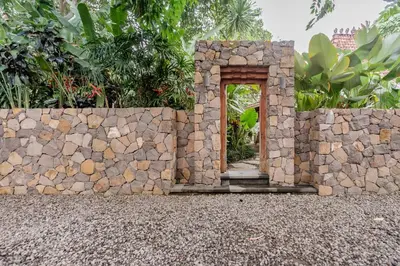 a stone wall with an opening in the middle at Wahyu wonderful 4Bd villa with huge garden and 2 pools in Seminyak