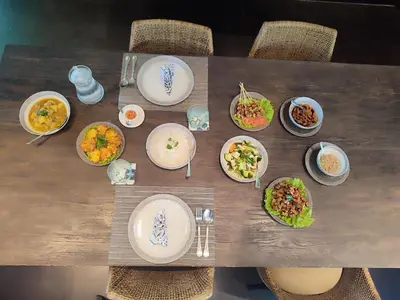 a table with plates and bowls of food on it at Wahyu wonderful 4Bd villa with huge garden and 2 pools in Seminyak