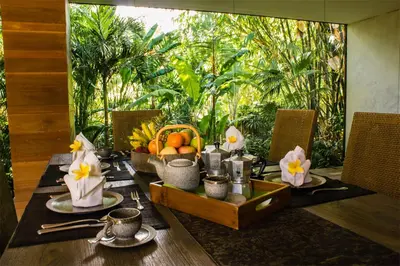 a dining table with a bowl of fruit on it at Wahyu lux honeymoon joglo 2 in Seminyak