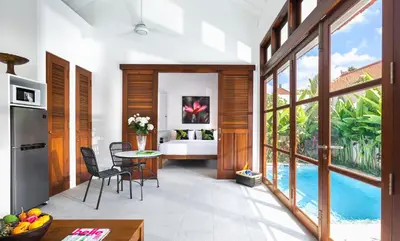 a kitchen with a table and chairs and a pool at Villa Bella Seminyak in Seminyak