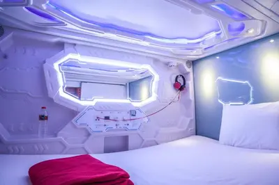 a small room with a bed in an airplane at PassGo Digital Airport Hotel Bali in Kuta