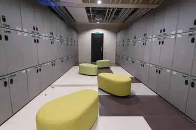 a locker room with green chairs and lockers at PassGo Digital Airport Hotel Bali in Kuta