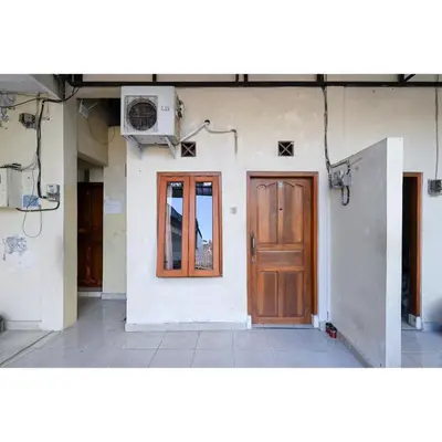 a house with a wooden door and a window at Pondok Syariah Denpasar Mitra RedDoorz in Kerobokan