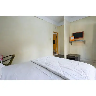 a bedroom with a white bed in a room at Pondok Syariah Denpasar Mitra RedDoorz in Kerobokan