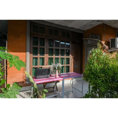 a table in front of a house with a laptop on it at Pondok Syariah Denpasar Mitra RedDoorz in Kerobokan
