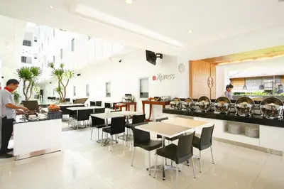 a man standing at a counter in a restaurant at Amaris Hotel Sunset Road - Bali in Kuta