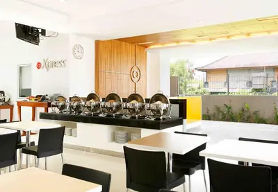 a restaurant with tables and chairs and wine glasses at Amaris Hotel Sunset Road - Bali in Kuta