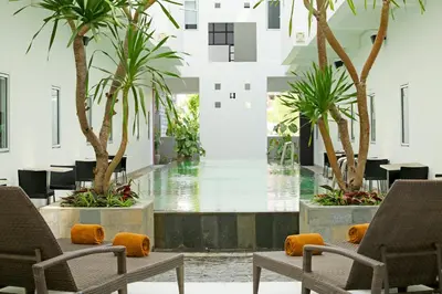 a lobby with two chairs and palm trees at Amaris Hotel Sunset Road - Bali in Kuta