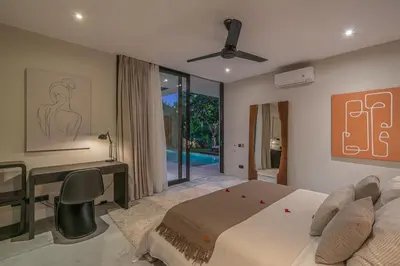 a bedroom with a bed and a desk and a desk at Villa Prana - High End Boutique Style Interior Design 5 BR Villa in Canggu