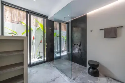 a bathroom with a shower and a glass door at Villa Prana - High End Boutique Style Interior Design 5 BR Villa in Canggu