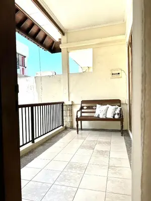 a porch with a bench on a balcony at Turtledove Guesthouse in Kerobokan