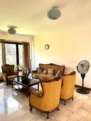 a living room with a couch and chairs and a table at Turtledove Guesthouse in Kerobokan