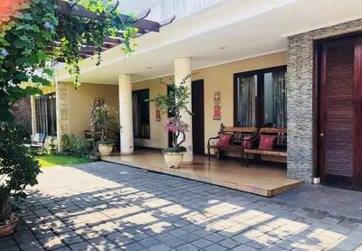 a courtyard of a house with benches and windows at Turtledove Guesthouse in Kerobokan