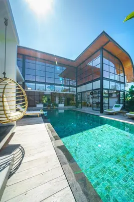 a house with a swimming pool in front of a building at Villa Mango 3 - Amazing 4-bdr Villa in Berawa ! PERFECT LOCATION ! in Canggu
