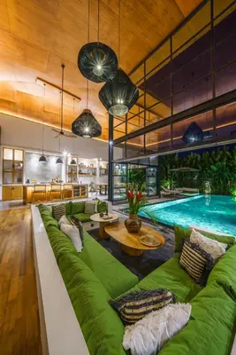 a living room with a green couch and a pool at Villa Mango 3 - Amazing 4-bdr Villa in Berawa ! PERFECT LOCATION ! in Canggu