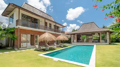 a villa with a swimming pool and a house at Villa Aloui by Villa Finder in Kerobokan