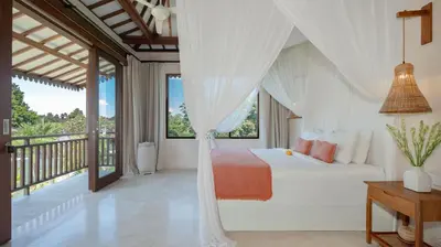 a bedroom with a white bed and a balcony at Villa Aloui by Villa Finder in Kerobokan