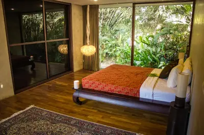 a bedroom with a bed and a large window at Luxury 4BR Villa with 2 Pools & Garden in Seminyak