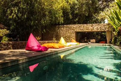 a pool with colorful pillows on the edge of it at Luxury 4BR Villa with 2 Pools & Garden in Seminyak