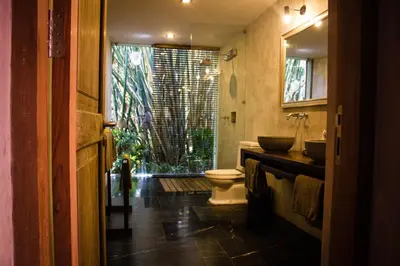a bathroom with a toilet and a sink and a window at Luxury 4BR Villa with 2 Pools & Garden in Seminyak