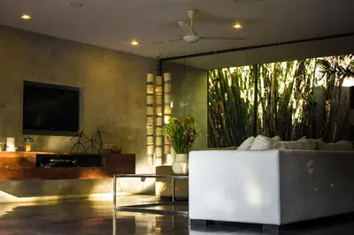 a living room with a white couch and a tv at Luxury 4BR Villa with 2 Pools & Garden in Seminyak